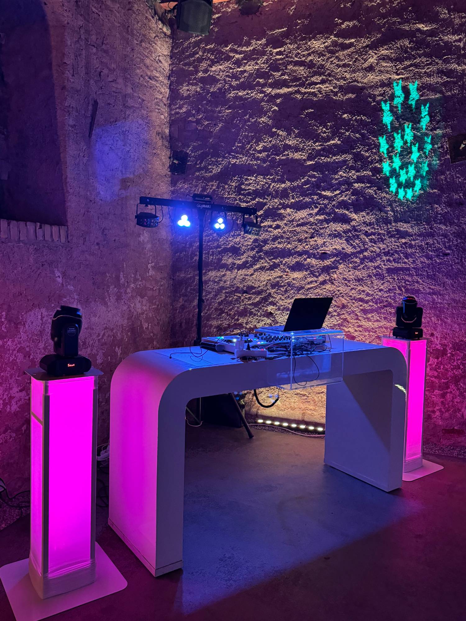 Aufgebautes Pult im Gewölbekeller, Stelen und Wand in Pink und Blau beleuchtet